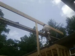 Carpenter setting a ridge beam over a new addition frame — Ice Dam Removal by Roofing Brothers in Oakville